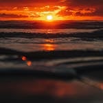 Stunning sunset with vibrant colors reflecting on the ocean, creating a tranquil seascape.