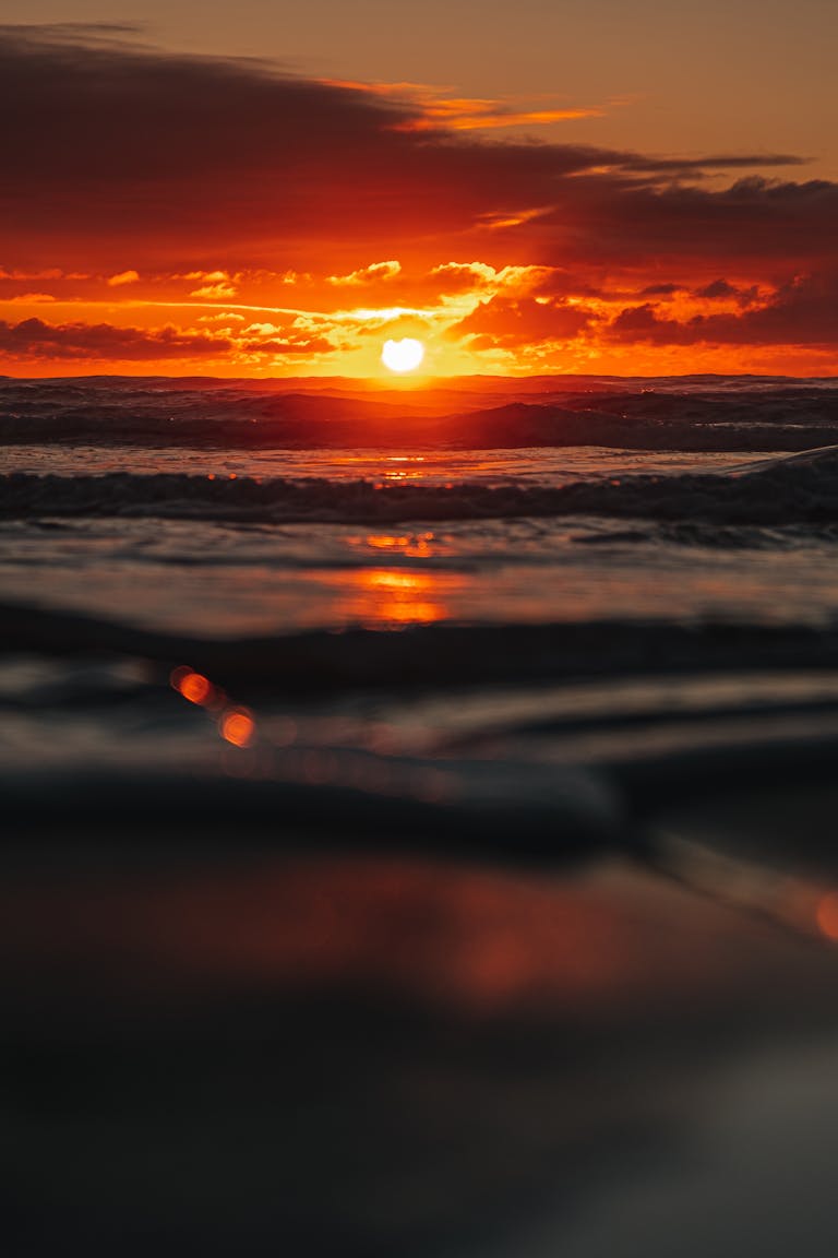 MANIFESTIERE 6 Stunning sunset with vibrant colors reflecting on the ocean, creating a tranquil seascape.